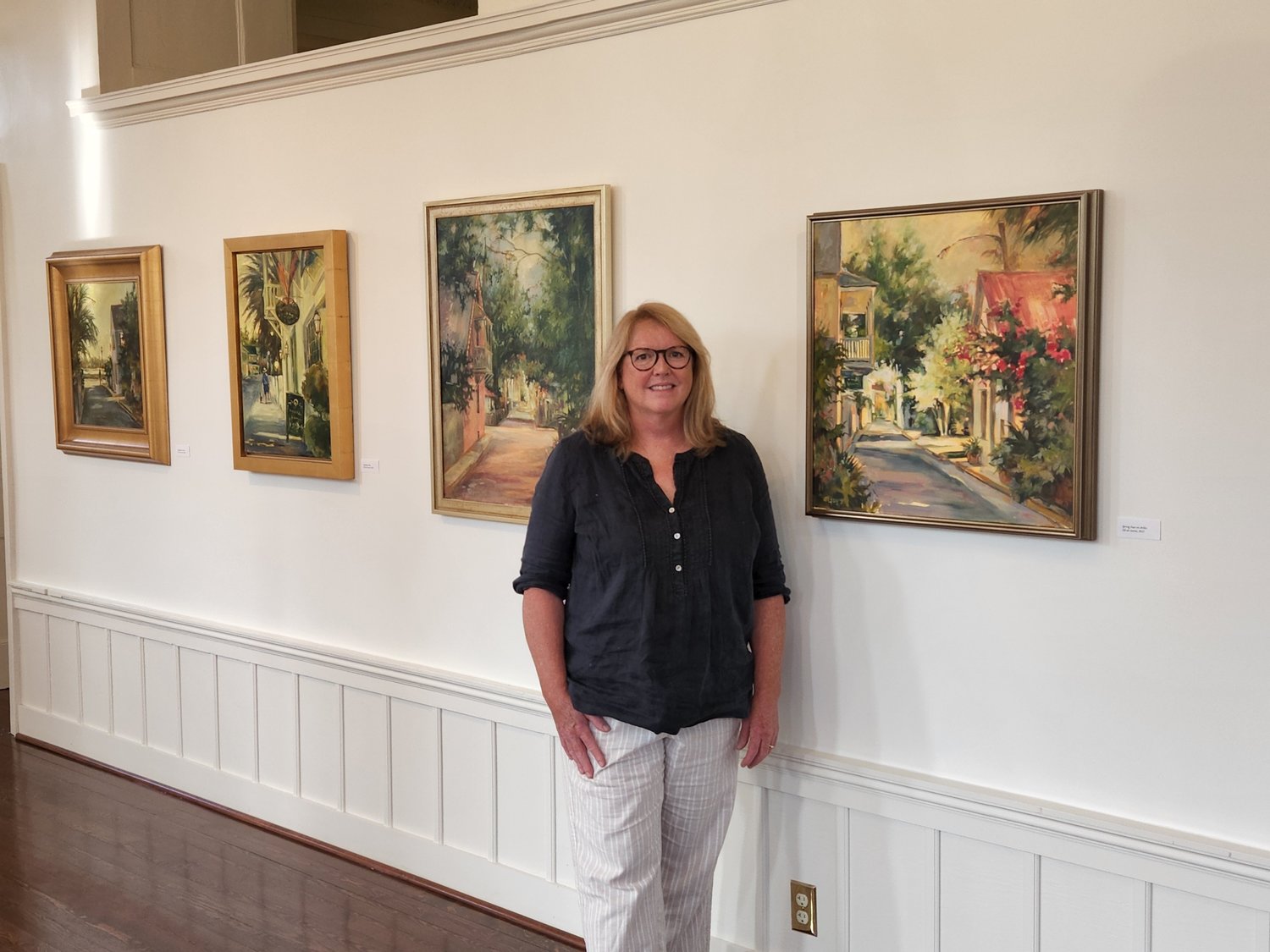 Martha Ferguson stands next to her paintings as she was the most recent local artist to be featured at the Lightner Museum in St. Augustine.